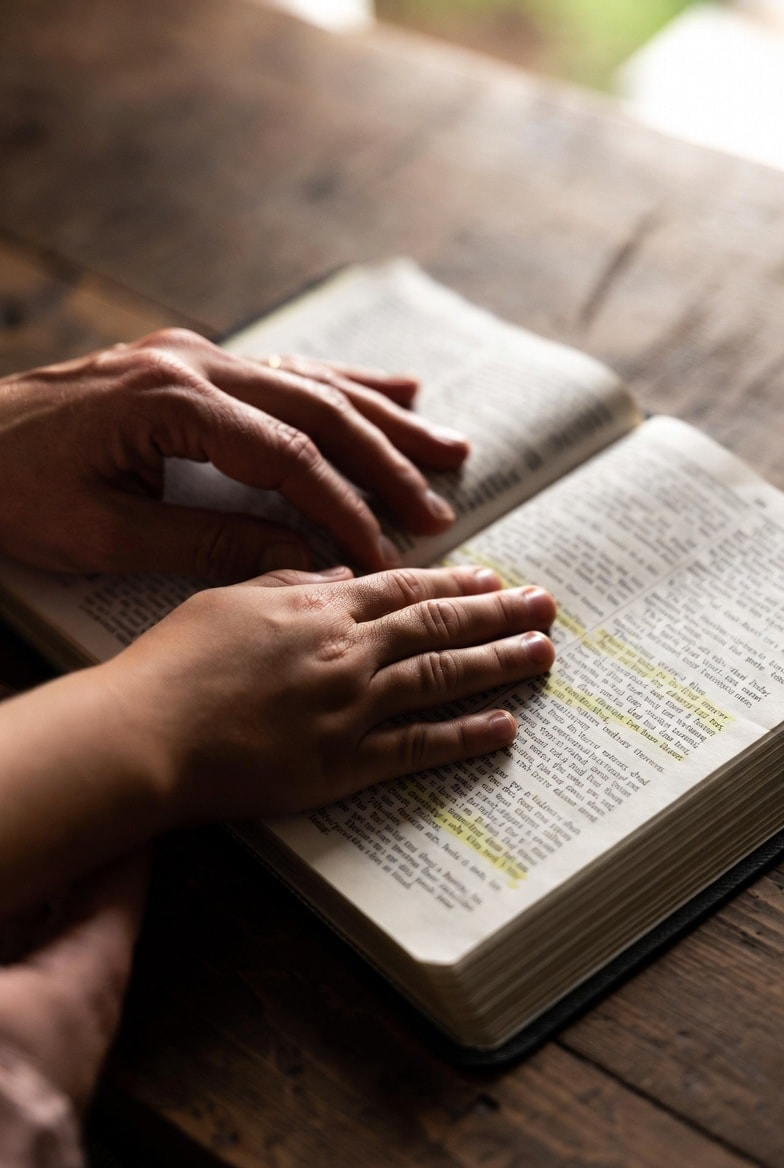 Hands resting on an open Bible